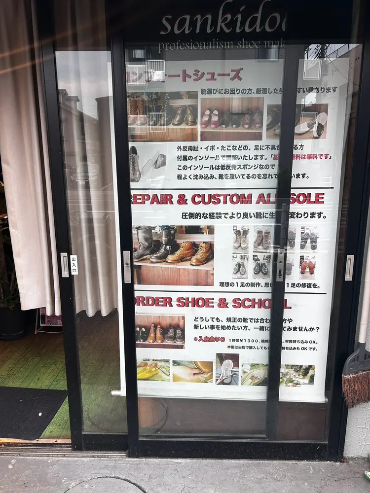 入口ガラスに貼られた、修理とコンフォートシューズの案内